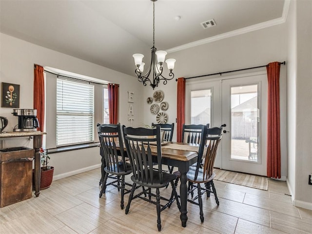 dining space with french doors, visible vents, crown molding, baseboards, and a chandelier