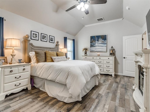 bedroom featuring ceiling fan, vaulted ceiling, wood finished floors, and visible vents