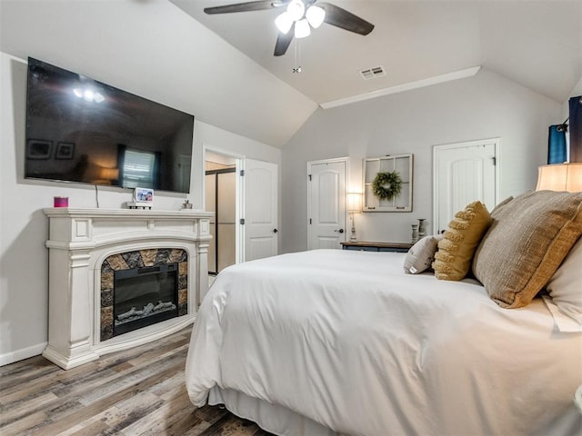 bedroom with ceiling fan, baseboards, wood finished floors, lofted ceiling, and visible vents