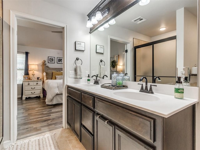 ensuite bathroom featuring visible vents, a sink, ensuite bath, and a stall shower