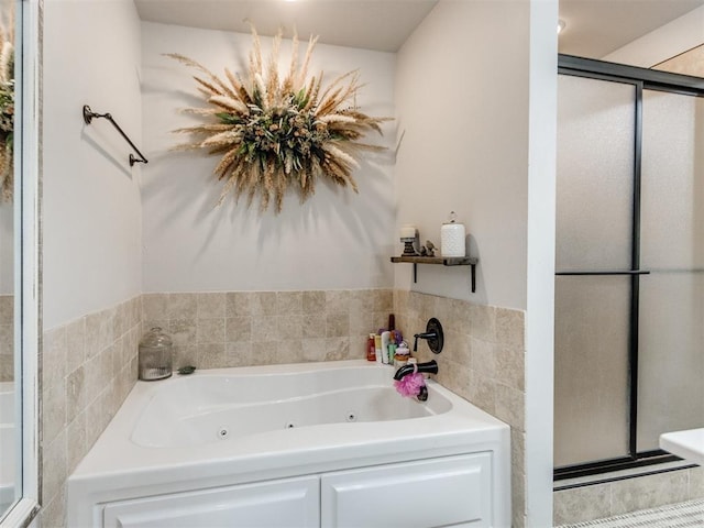 full bathroom featuring a whirlpool tub and a stall shower