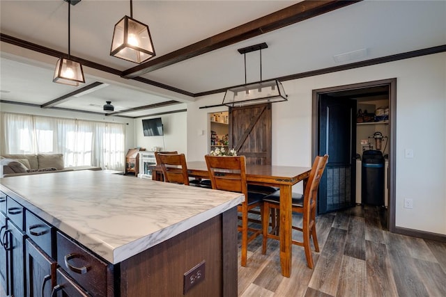 kitchen with a barn door, open floor plan, light countertops, beam ceiling, and dark wood-style floors