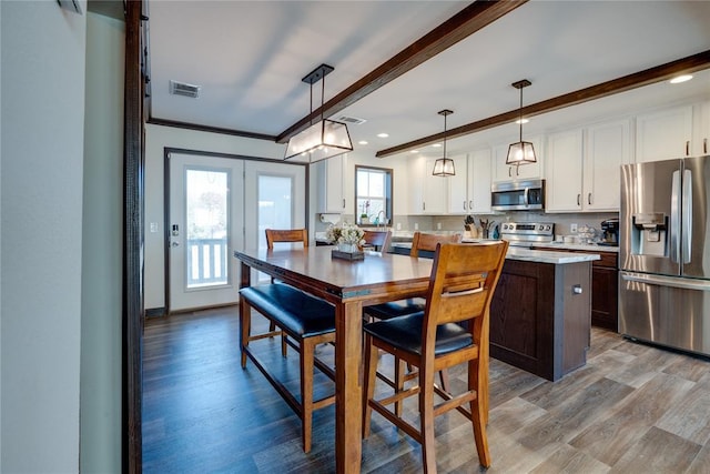 kitchen featuring stainless steel appliances, light countertops, beam ceiling, and white cabinets