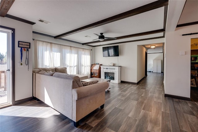 living area featuring a fireplace, wood finished floors, visible vents, a ceiling fan, and beamed ceiling