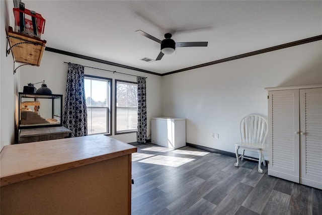 unfurnished office featuring dark wood-style floors, a ceiling fan, visible vents, and crown molding