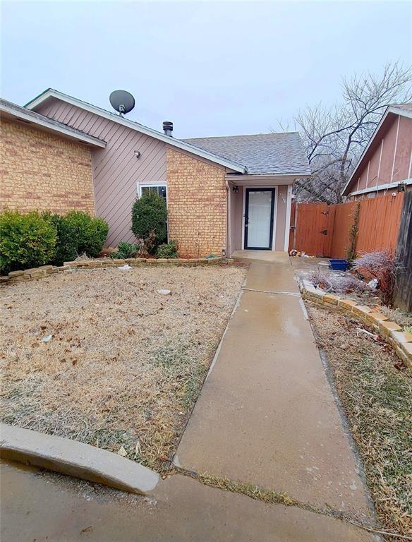 view of front of house with brick siding and fence