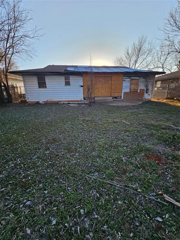 back of house with a lawn and fence