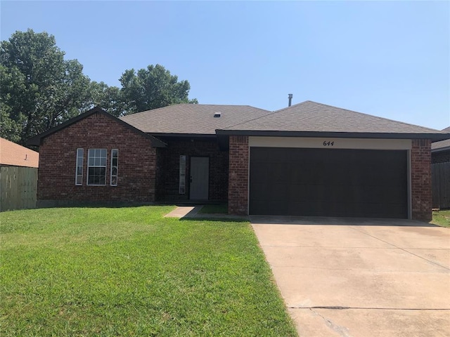 ranch-style home featuring driveway, roof with shingles, an attached garage, a front lawn, and brick siding