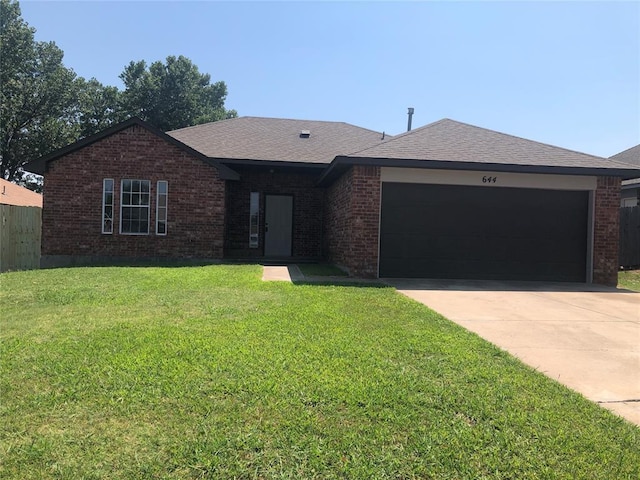 ranch-style home with a garage, brick siding, driveway, and a front lawn