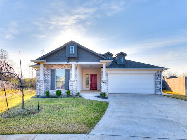 view of front of house featuring brick siding, an attached garage, fence, driveway, and a front lawn