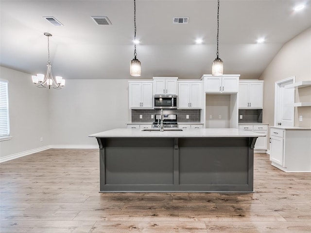 kitchen featuring visible vents, appliances with stainless steel finishes, and white cabinets