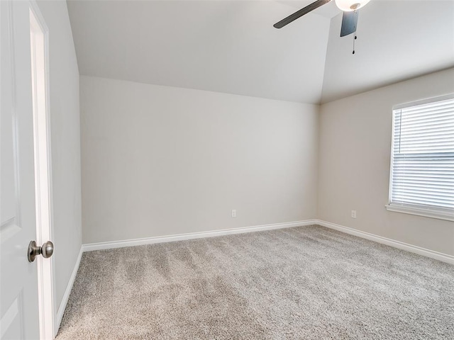 carpeted spare room with lofted ceiling, ceiling fan, and baseboards