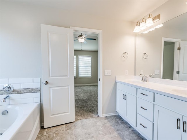 full bath with double vanity, a garden tub, a ceiling fan, and a sink