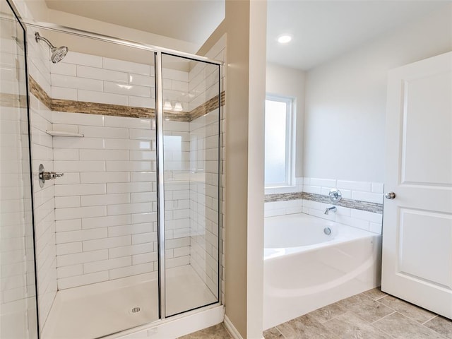 bathroom featuring a stall shower and a garden tub