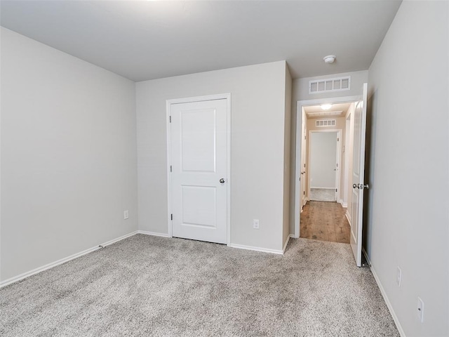 unfurnished bedroom with baseboards, visible vents, and carpet flooring