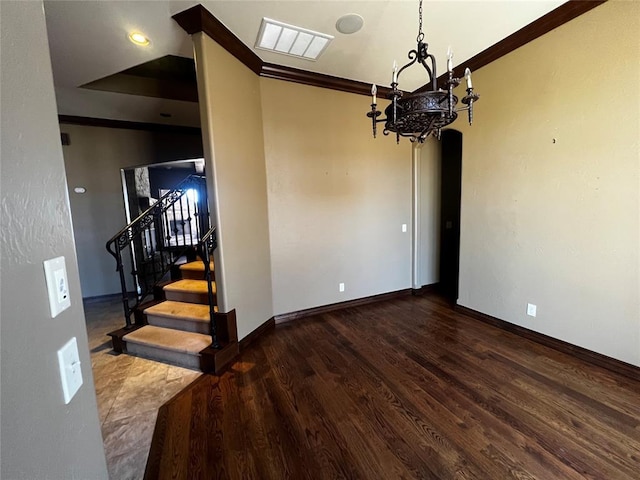 spare room with wood finished floors, visible vents, baseboards, stairway, and crown molding