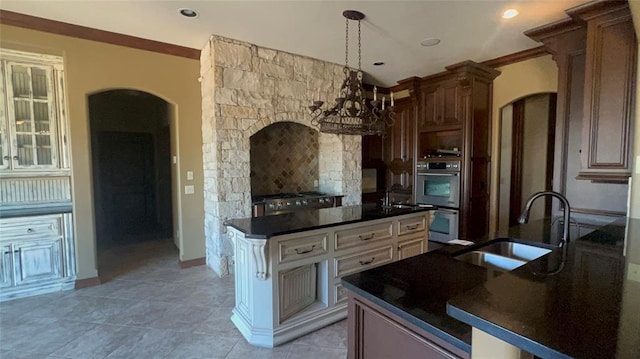 kitchen with arched walkways, stainless steel double oven, a sink, and range