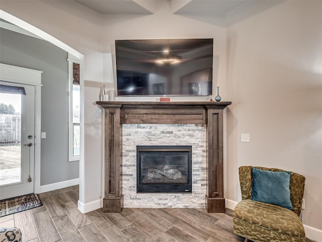 interior space featuring wood finish floors, a fireplace, and baseboards