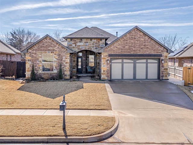 view of front of property featuring driveway, an attached garage, fence, and brick siding