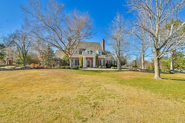 view of front facade featuring a chimney and a front yard