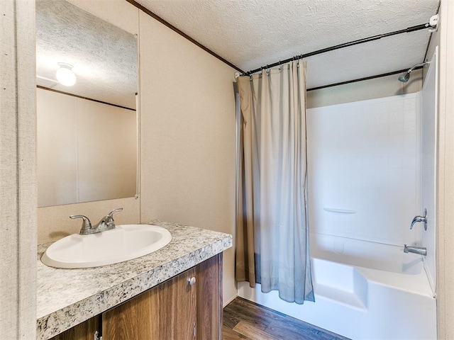 full bathroom featuring shower / tub combo with curtain, a textured ceiling, vanity, and wood finished floors