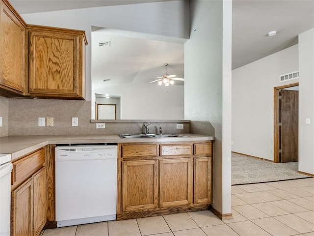 kitchen featuring light tile patterned floors, a sink, visible vents, vaulted ceiling, and dishwasher