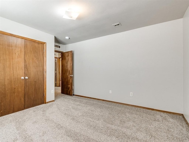 unfurnished bedroom with a closet, visible vents, baseboards, and carpet flooring