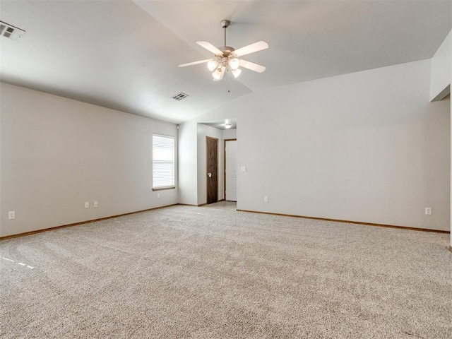 empty room with visible vents, lofted ceiling, light colored carpet, and a ceiling fan