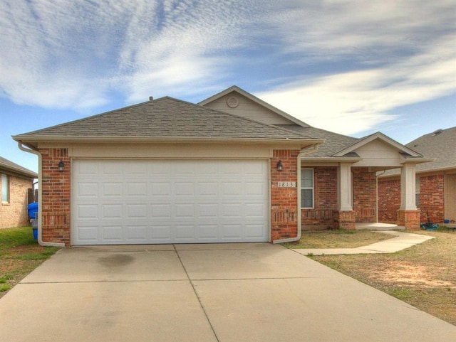 ranch-style home with concrete driveway, a garage, brick siding, and a shingled roof