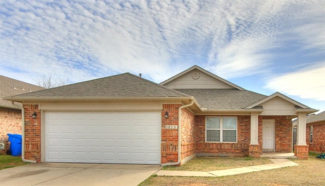 view of front of house featuring brick siding, driveway, an attached garage, and roof with shingles