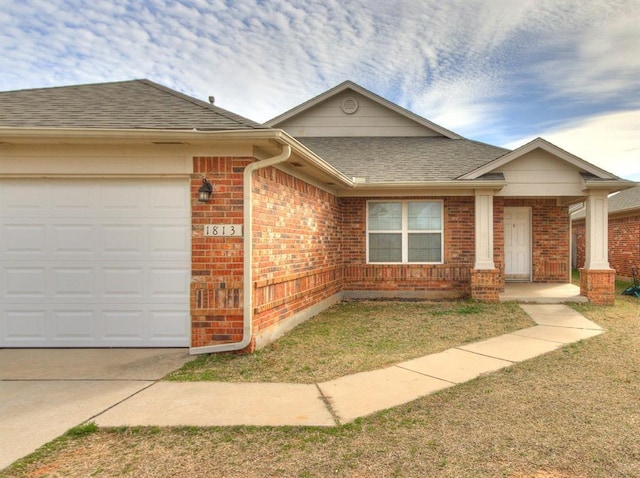 ranch-style house featuring an attached garage, brick siding, and a shingled roof