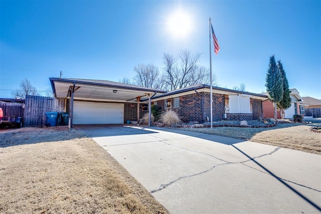 view of front of house with concrete driveway, brick siding, an attached garage, and fence