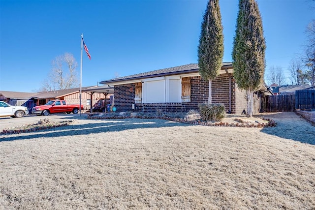 ranch-style house featuring fence and brick siding