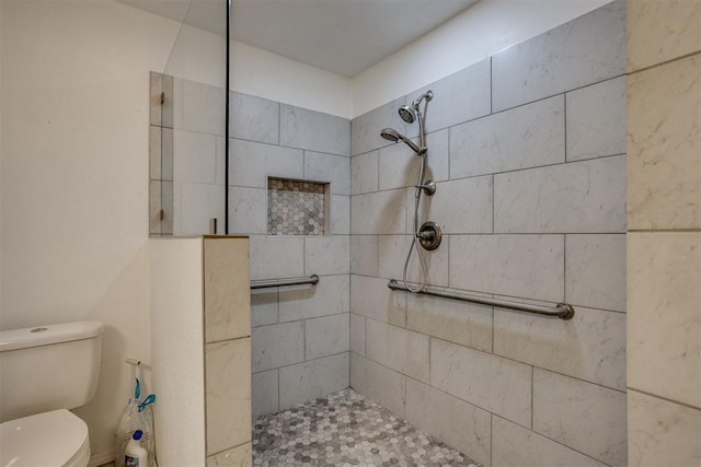 bathroom featuring tiled shower and toilet