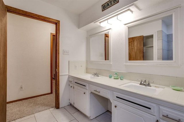 bathroom with double vanity, decorative backsplash, and a sink