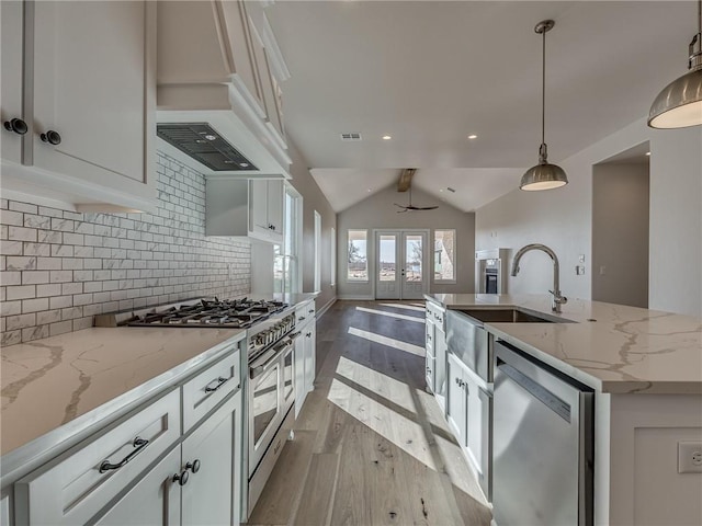 kitchen with stainless steel appliances, french doors, backsplash, and white cabinets