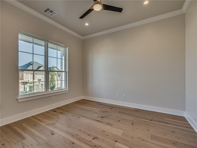 unfurnished room featuring baseboards, visible vents, wood finished floors, and ornamental molding