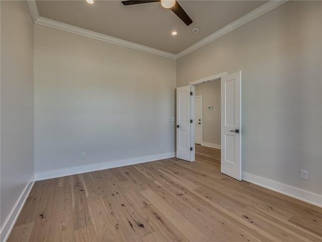 spare room featuring baseboards, a ceiling fan, light wood-style flooring, and crown molding