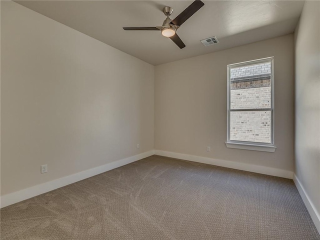 spare room with ceiling fan, baseboards, visible vents, and dark carpet