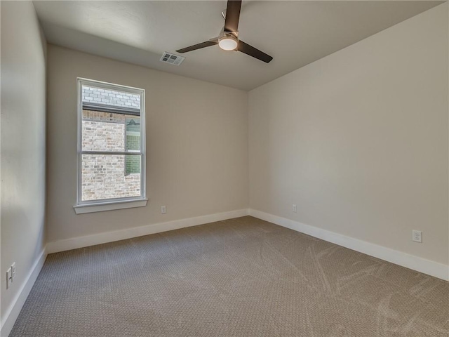 carpeted spare room featuring baseboards, visible vents, and a ceiling fan