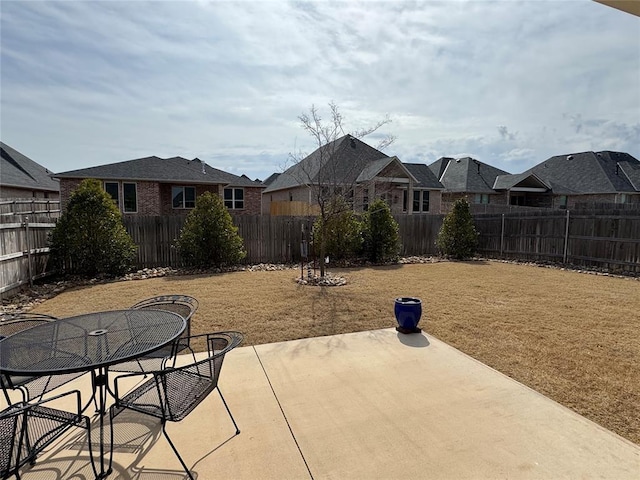 view of patio / terrace featuring outdoor dining space, a fenced backyard, and a residential view