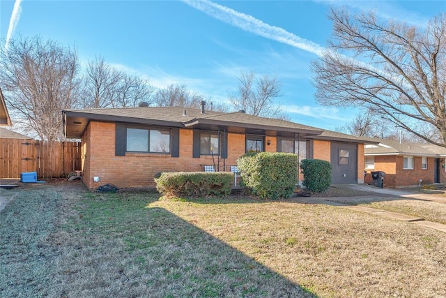 view of front of house featuring a front yard, fence, and brick siding