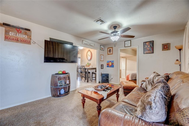 living room with baseboards, ceiling fan, visible vents, and carpet flooring