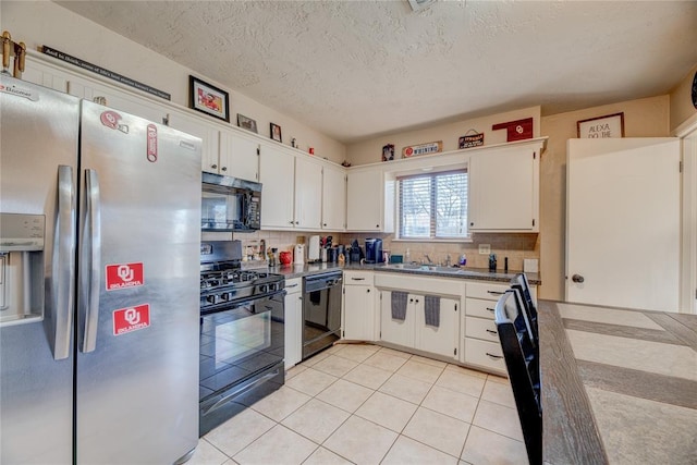 kitchen featuring light tile patterned floors, black appliances, tasteful backsplash, and white cabinets