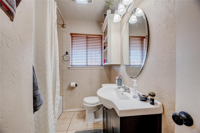 full bathroom featuring a textured wall, tile patterned flooring, toilet, vanity, and a shower with curtain