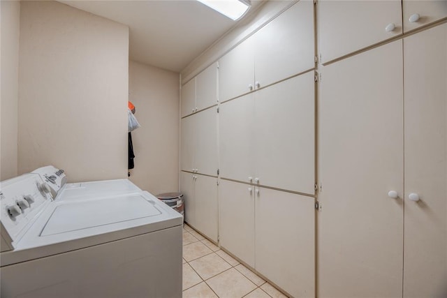 clothes washing area with cabinet space, independent washer and dryer, and light tile patterned floors