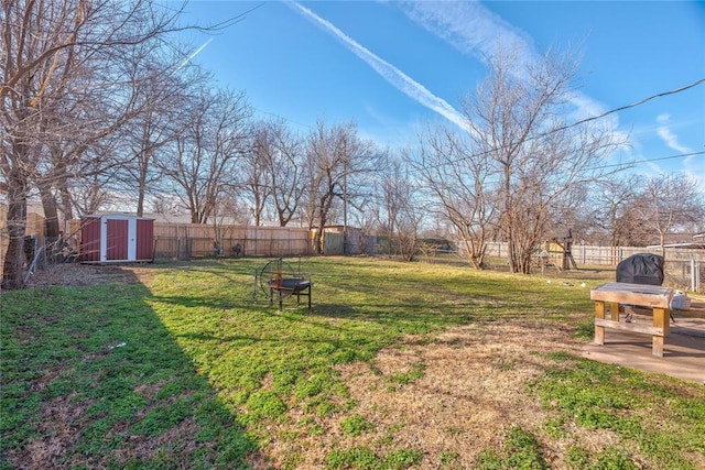 view of yard with a fenced backyard, an outdoor structure, and a shed