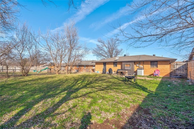 view of yard featuring a playground, a fenced backyard, and central AC unit