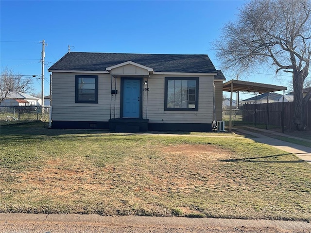 bungalow-style home featuring a carport, roof with shingles, fence, and a front lawn