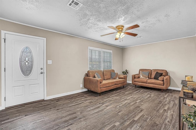 living area with a textured ceiling, wood finished floors, visible vents, and a ceiling fan